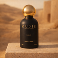Oudie Heaven Scent perfume bottle with gold cap on a desert background