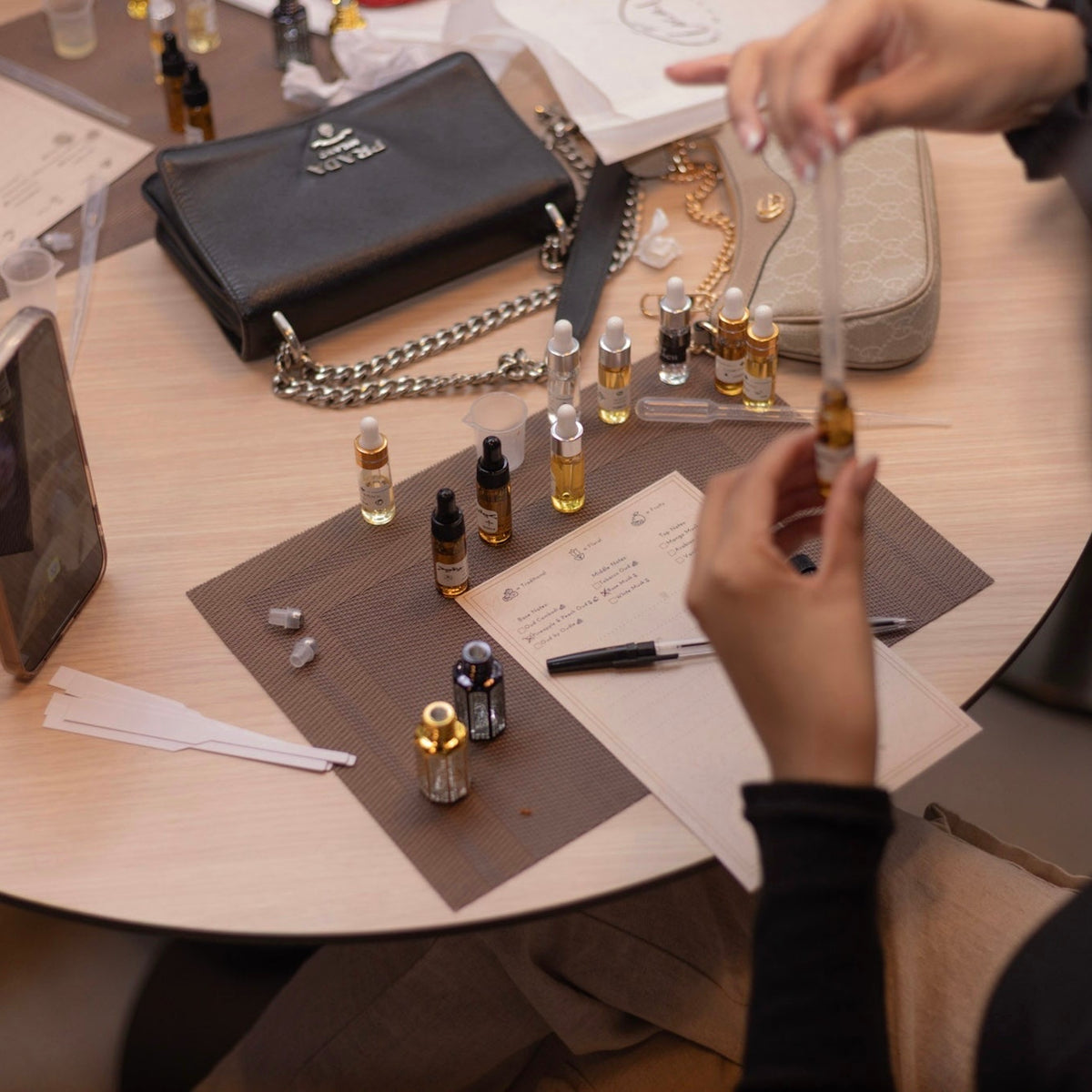 An engaging, hands-on station where guests become artisans at the Local by Masrawy. The table is fully equipped with essential oils, pipettes, and mixing guides, allowing participants to actively blend their own custom fragrances into elegant crystal bottles for a truly personalized experience.
