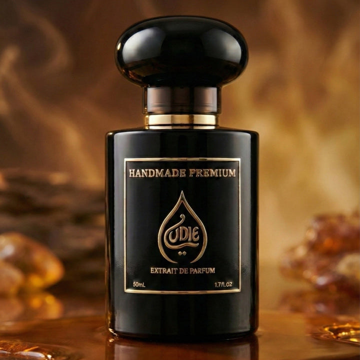 Black perfume bottle with gold label on a reflective surface with amber background