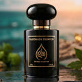 Black perfume bottle with gold accents on a reflective surface, blurred natural background